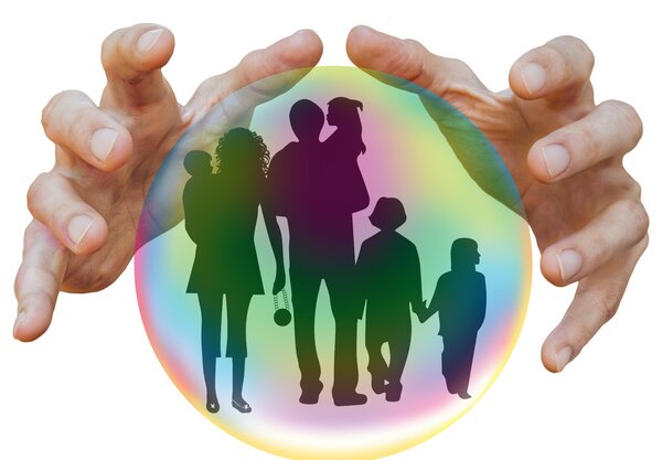 H&auml;nde umfassen eine Kugel, in der Eltern mit Kindern als Schatten abgebildet sind.
